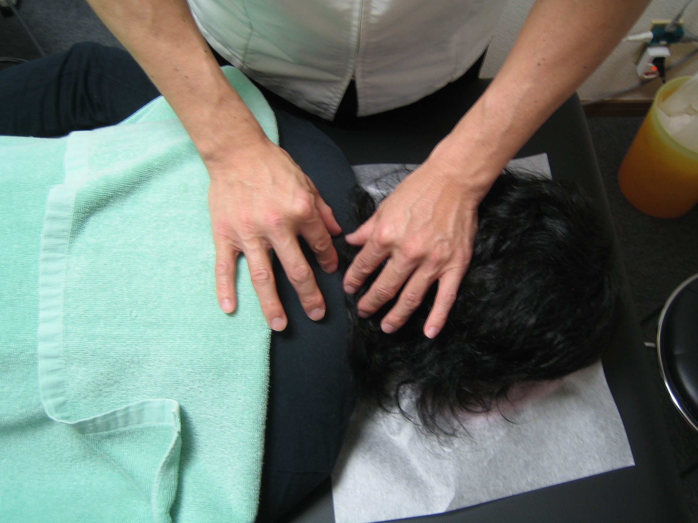 首肩の緊張をやさしく確認している施術風景